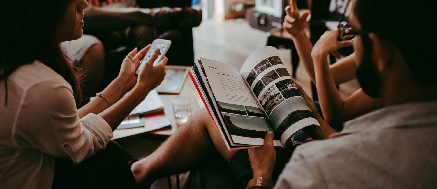 girl holding the mobile & boy with a book
